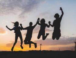 happy-friends-silhouettes-jumping-sunset Ilustrasi siluet bahagia bersama teman. (marymarkevich/Freepik)