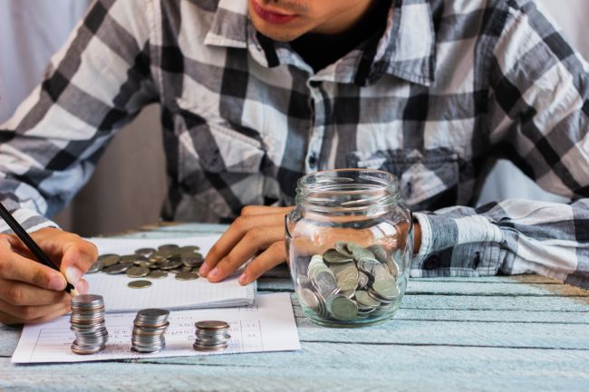 Photo jar with savings coins on table. Image by Freepik
